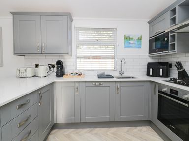 A kitchen with grey cabinets and appliances at Thirlmere Scar in Troutbeck Bridge