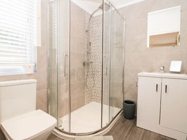 A bathroom with a shower, toilet, and sink at Thirlmere Scar in Troutbeck Bridge