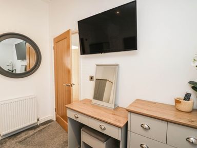 A bedroom with a television and a mirror at Thirlmere Scar in Troutbeck Bridge