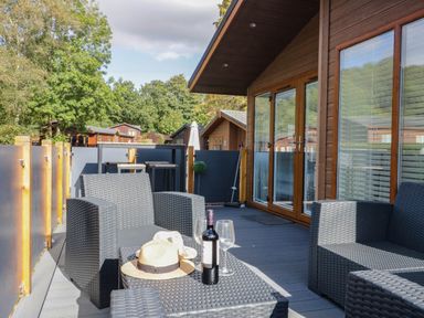 A deck with outdoor furniture and wine at Thirlmere Scar in Troutbeck Bridge