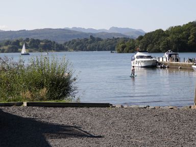 A person standing on a paddleboard in water at Thirlmere Scar in Troutbeck Bridge