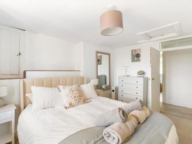 A bedroom with a bed, dresser, mirror, and lamp at the property