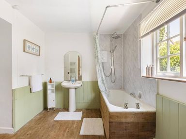 A bathroom with a bath tub and sink at The Old Barn in Manchester