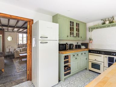 A kitchen with green cabinets and appliances at The Old Barn in Manchester