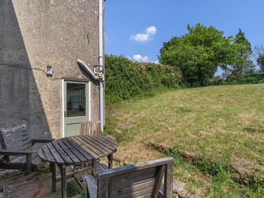 A garden with a wooden table and chairs outside a house at The Old Barn in Manchester