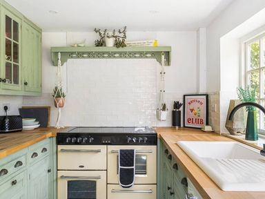 A kitchen with an oven, sink, and shelves at The Old Barn in Manchester