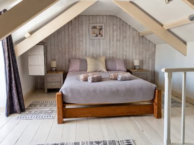 A bedroom with a bed and nightstands at The Old Barn in Manchester
