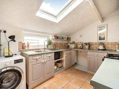 A kitchen with sink, washing machine, and microwave at The Old Barn in Manchester