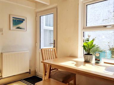 A dining room with a table, chair, and plant at a property