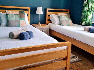 A bedroom with two beds and towels on the beds at  