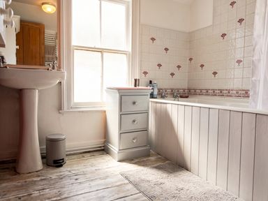 A bathroom with a bathtub, sink, and cabinet at The Old Barn in Manchester