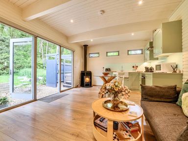A living room with a sofa, table, and kitchen area at a property