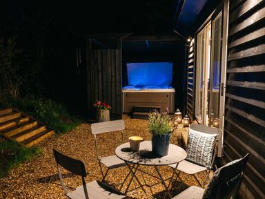 An outdoor area with a hot tub, table and chairs at a property