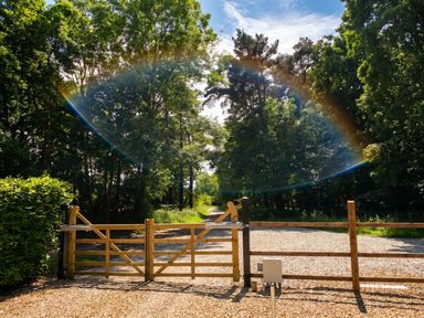 A gate leading to a path surrounded by trees at a property