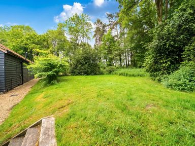 A garden with grass and trees at The Old Barn in Manchester