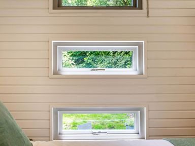 Two windows on a wall in a bedroom at an unspecified location
