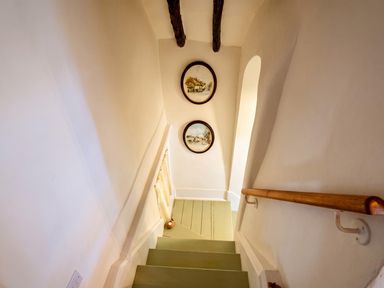 A staircase with paintings on the wall at The Old Barn in Manchester