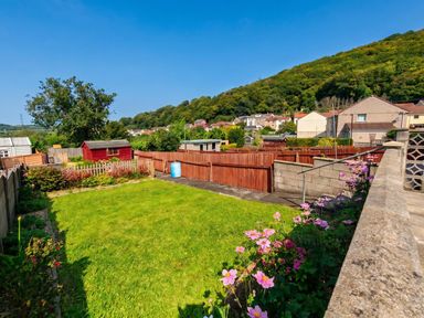 A garden with a lawn, flower bed, and shed at the property