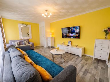 A living room with a TV and sofa at The Old Barn in Manchester