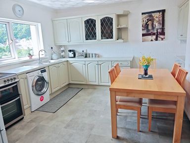 A kitchen with a table and chairs at the property in location