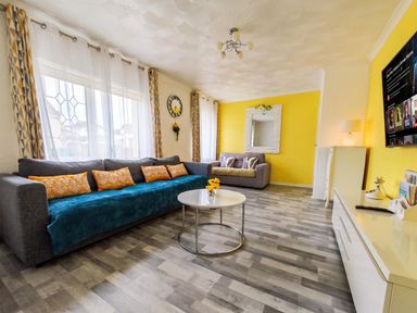 A living room with a grey sofa and yellow walls at The Old Barn in Manchester