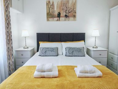 A bedroom with a bed, bedside tables, and lamps at 