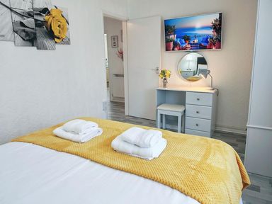 A bedroom with a bed, desk, and television at The Old Barn in Manchester