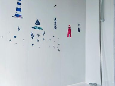 A bathroom with nautical wall decals and a shower at a property