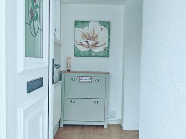 A hallway with a drawer unit and a flower painting at the property in 