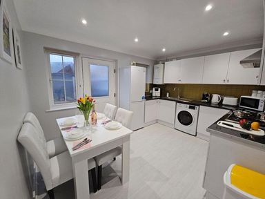 A kitchen with a dining table and appliances at The Old Barn in Manchester