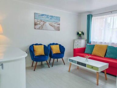 A living room with a red sofa and blue armchairs at 