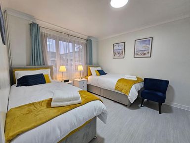 A bedroom with two beds and a bedside table at the property in the location