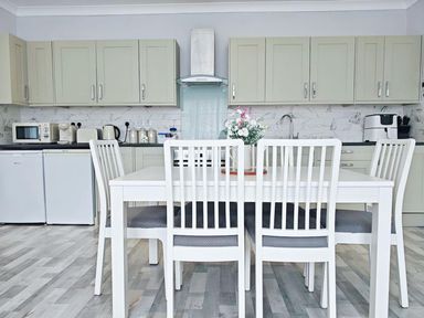A kitchen with a dining table and chairs at the property in location