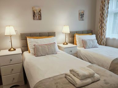 A bedroom with two beds and bedside lamps at The Old Barn in Manchester