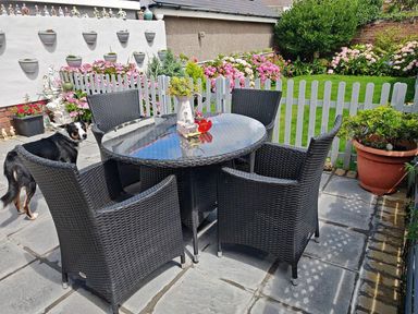 A garden with a table and chairs and flowers at 