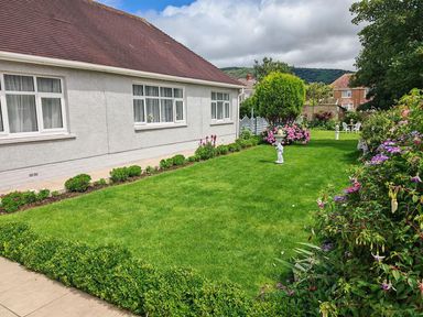 A garden with lawn and flowers in front of a house