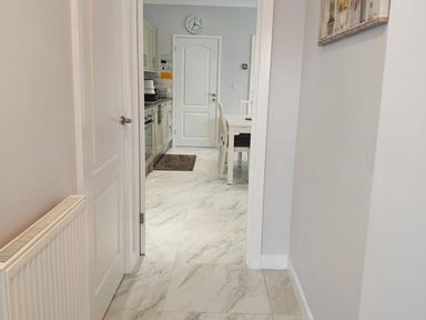 A hallway leading to a kitchen with a table and chairs at a residential property