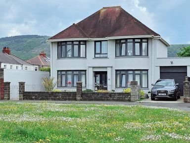 A house with a garden and a car parked outside