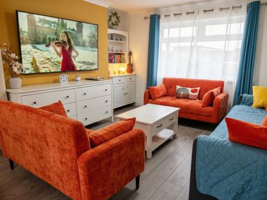 A living room with orange sofas and a television at the property