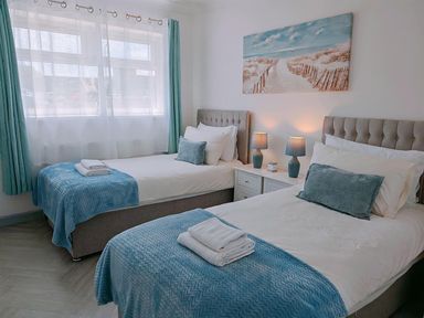 A bedroom with two beds and a painting on the wall at the property