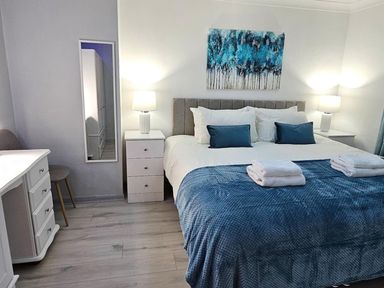 A bedroom with a bed, dresser, and lamp at The Old Barn in Manchester