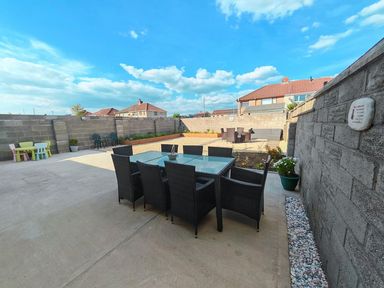 A garden with a dining table and chairs at a residential property