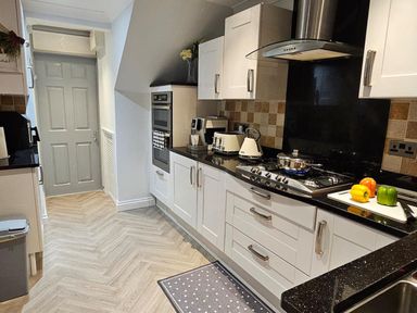 A kitchen with a stove, sink, and door at the property located in 