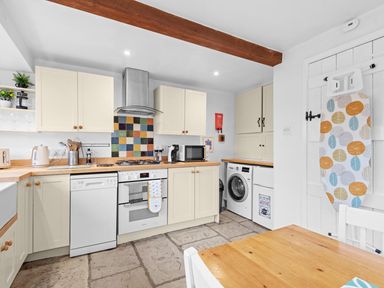 A kitchen with appliances and wooden table at The Old Barn in Manchester