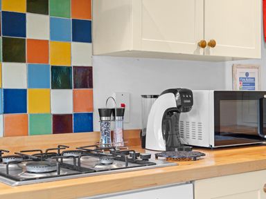 A kitchen with a gas stove and microwave at The Old Barn in Manchester