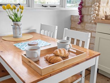 A dining room with a table and chairs and a tray of food at 