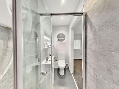 A bathroom featuring a shower, toilet, and sink with a mirror at the property in location