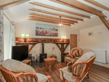 A living room with a sofa and a television at Bryn Eithin in Penygroes