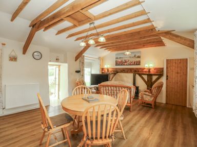 A dining room with a table and chairs at Bryn Eithin in Penygroes
