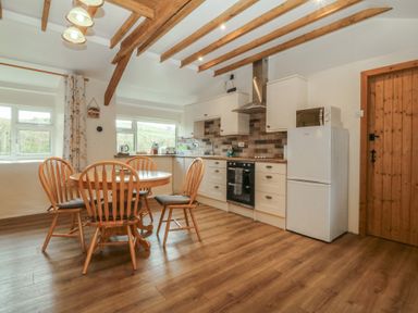 A kitchen with a table and chairs at Bryn Eithin in Penygroes